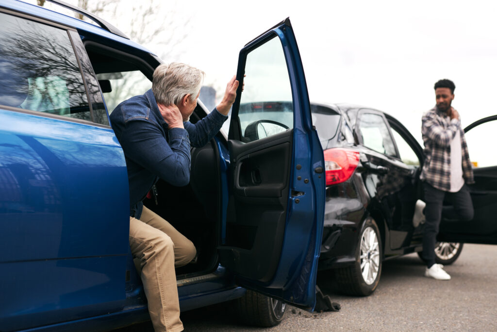 Senior and Younger Male Drivers Get Out of Cars and Inspect Damage After Road Traffic Accident